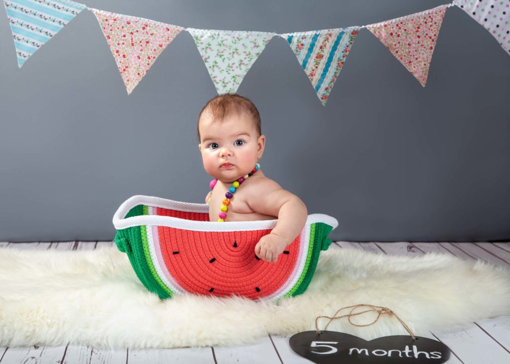 5 month old baby in a watermelon shaped container
