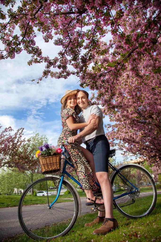 Couple on a bike under cherry blossoms