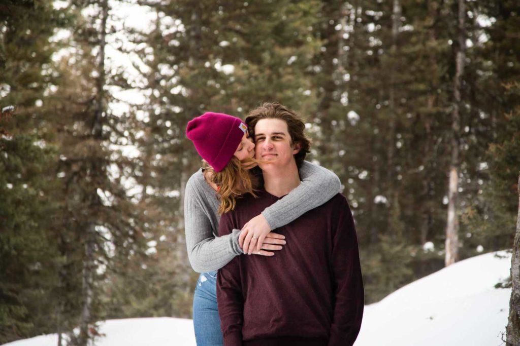 couple kissing in snowy forest