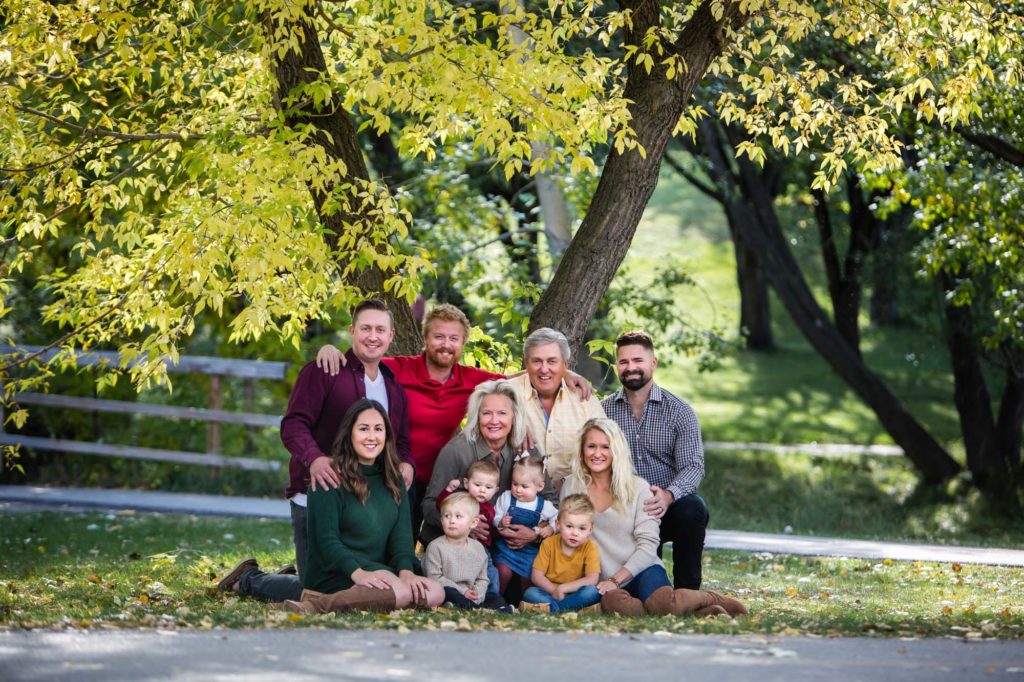 extended family under a big yellow tree in the park