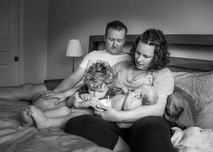 family sitting on a bed