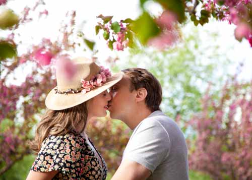 couple kissing under cherry blossoms