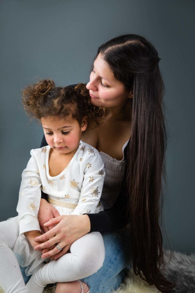 little girl sitting in her mother's lap