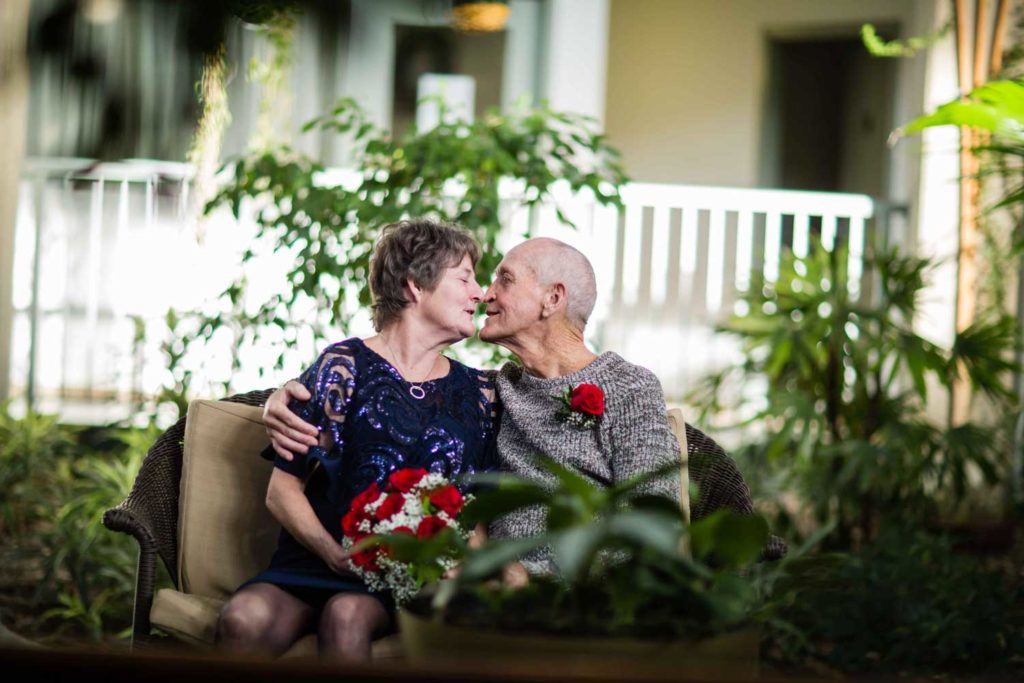 senior couple kissing on a bench