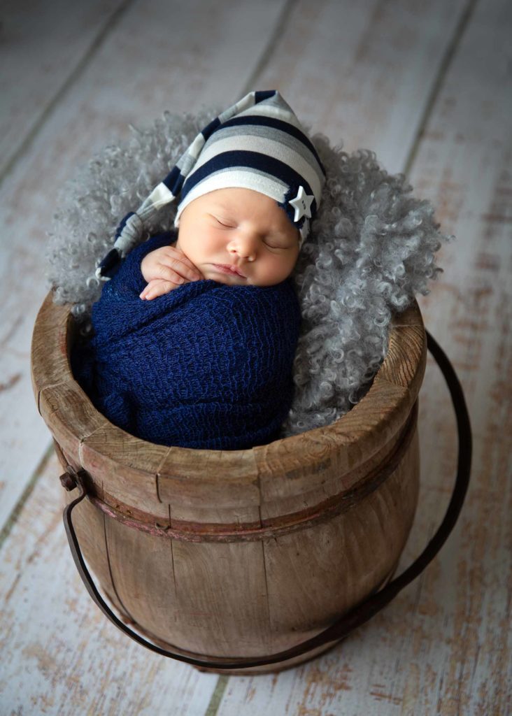 baby boy in a wooden bucket