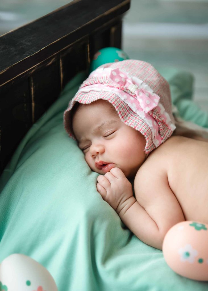 newborn baby lying on a bed