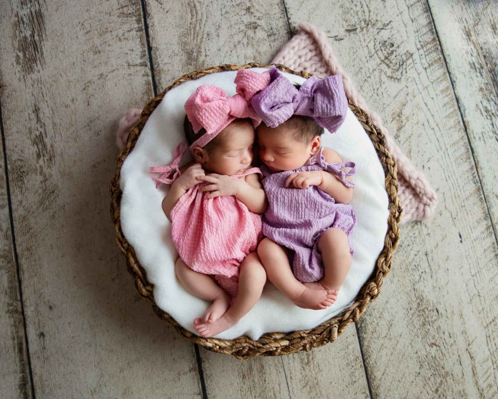 twin newborn girls in a basket