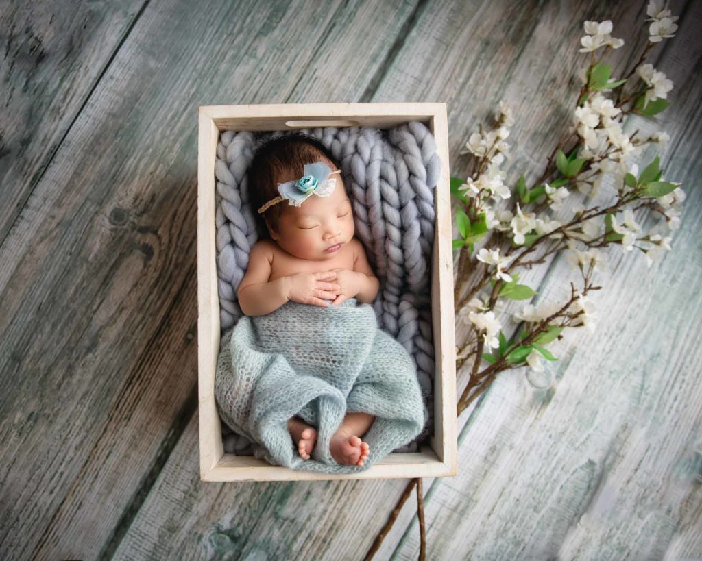 newborn baby girl in a wooden box