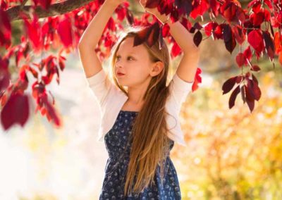 girl holding on a red tree