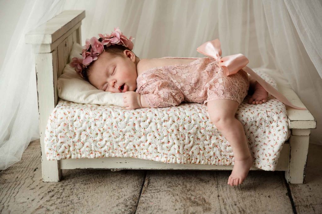 newborn baby lying on the bed