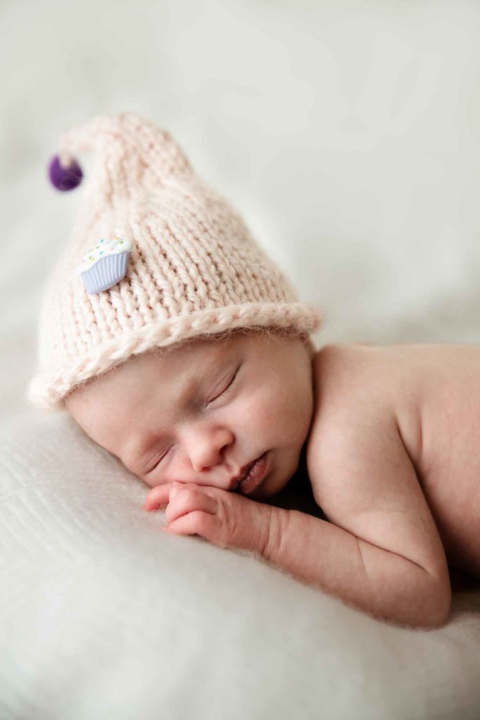 newborn baby with a pink hat