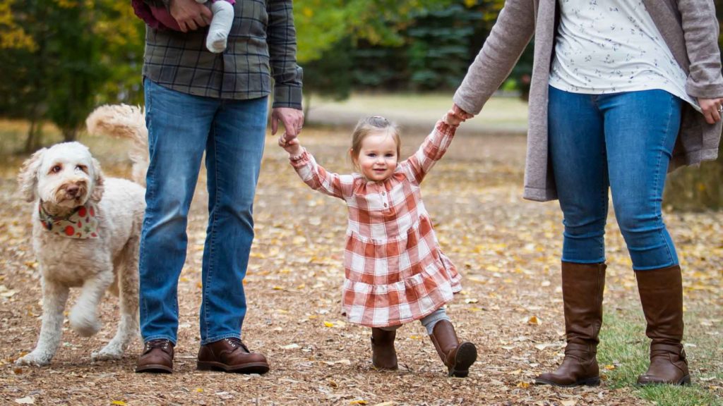 little girl walking with parents