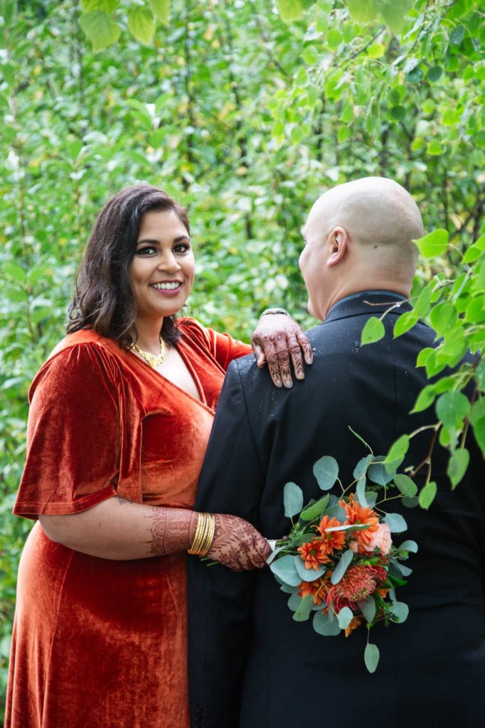 bride and groom among green leaves