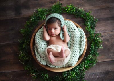 newborn baby in a wooden bowl