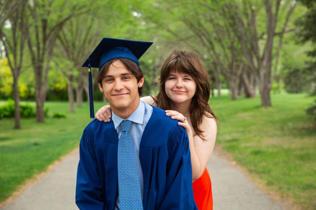graduating boy and his sister in the park