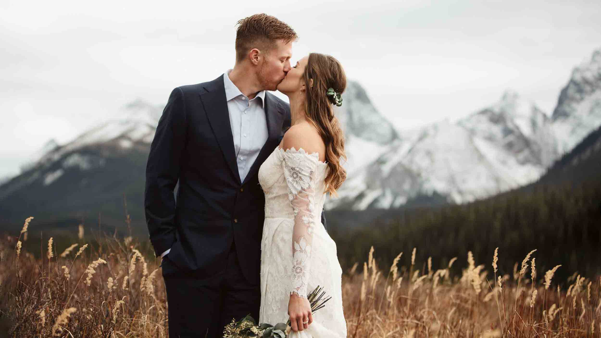 wedding couple kissing with mountain view in the background