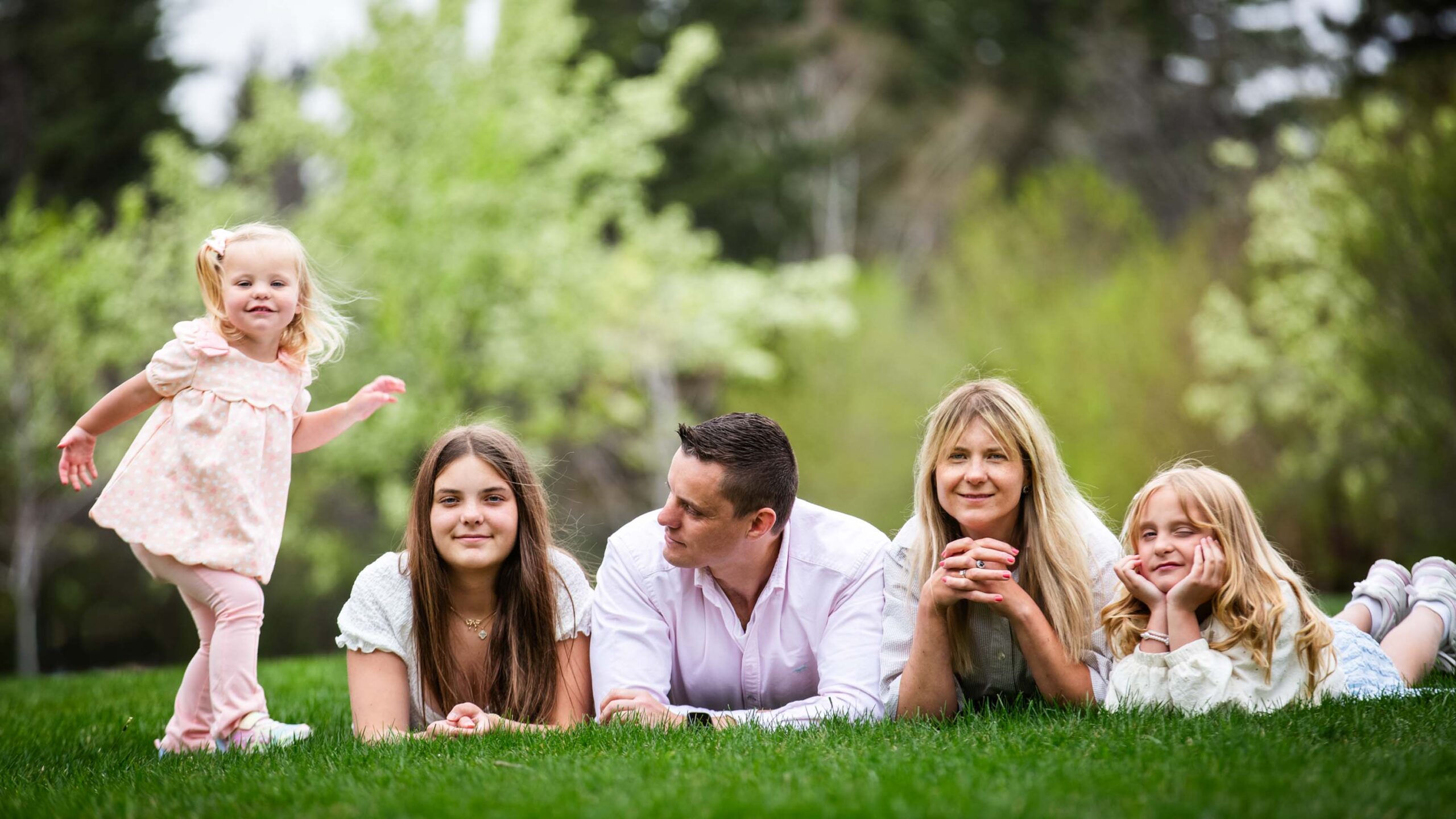 Family of five lying in the grass together during an outdoor photo session