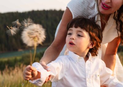 Mother and son blowing a dandelion during a fall family session in Calgary