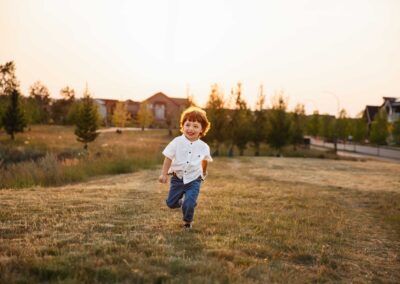 Smiling toddler running toward camera at golden hour