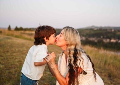 Mother and son sharing a kiss in a golden field