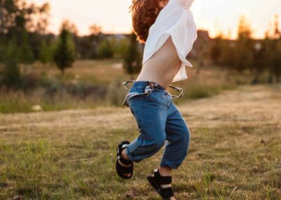 Toddler leaping joyfully into the air at sunset during a fall family session