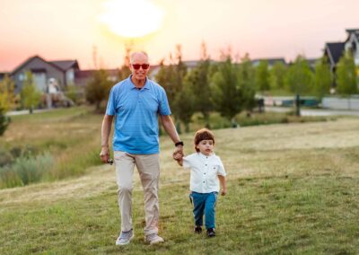 Grandfather and grandson walking together at sunset