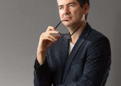 young man holding a glasses up against his face