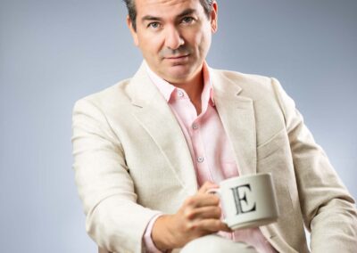 CEO headshot-sitting with a coffee mug in his hand