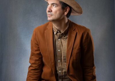 Cowboy sitting on a bench in a studio